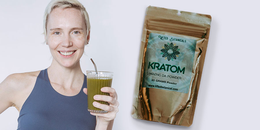 smiling woman with glass of green smoothie with straw beside a kratom powder in gold packaging